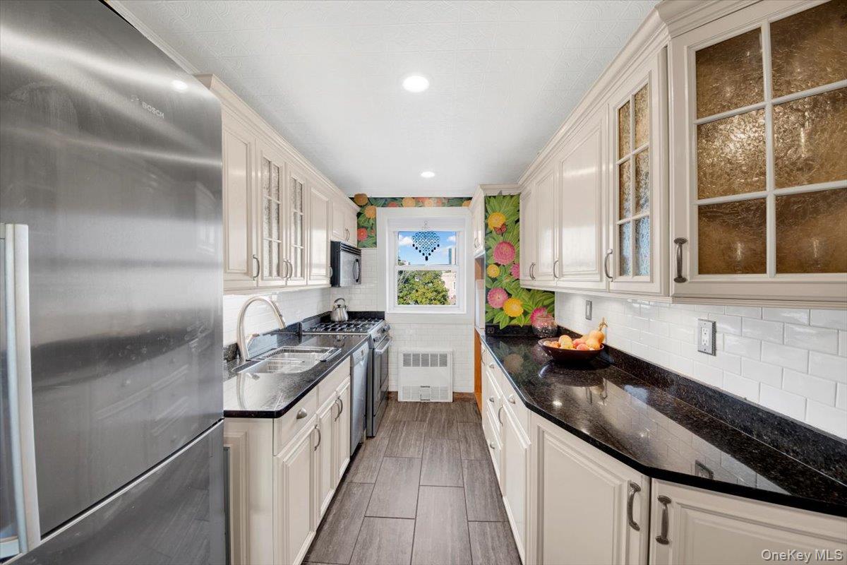 266 Pelham Road, Unit 5H New Rochelle, NY 10805 - Photo 4 of 27 a kitchen with a sink stove top oven and cabinets