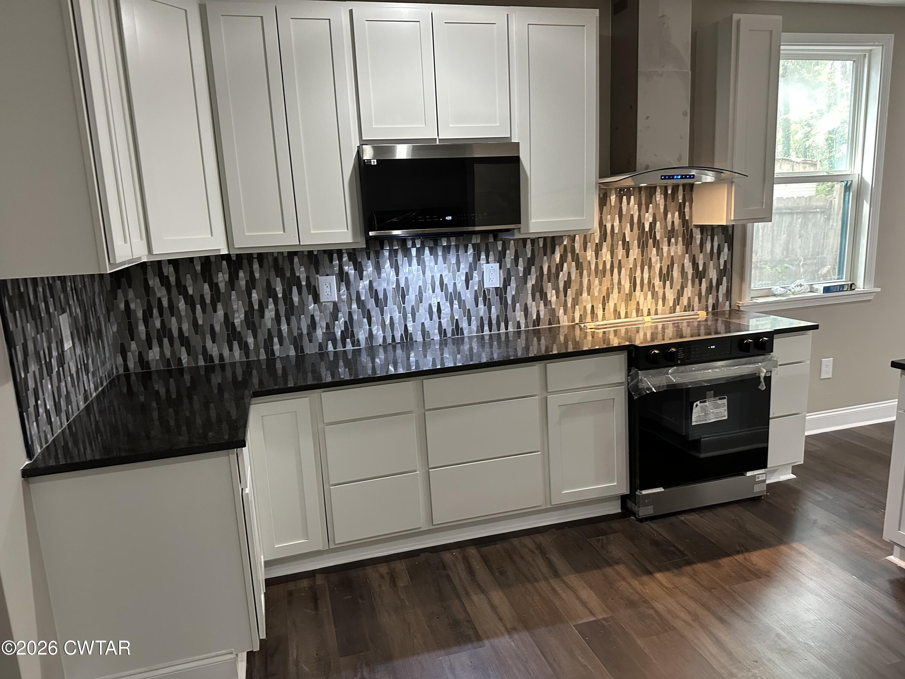 237 Talbot Street Jackson, TN 38301 - Photo 35 of 38 a kitchen with granite countertop white cabinets and black appliances