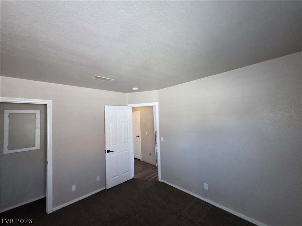 2275 Ramsgate Drive Henderson, NV 89074 - Photo 75 of 84 A versatile room awaits personalization, featuring soft carpet and access to other areas of the home.