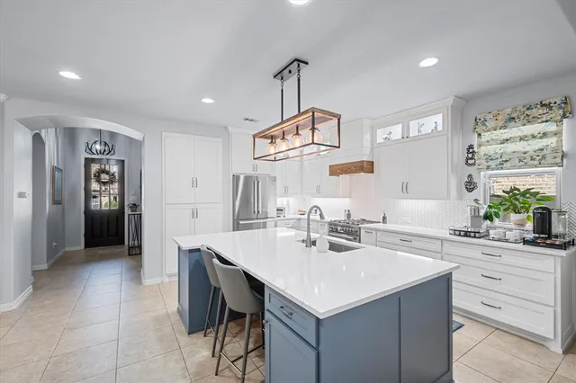 a kitchen with a sink a stove a dining table and chairs