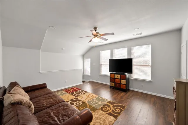 a living room with furniture and a flat screen tv with wooden floor