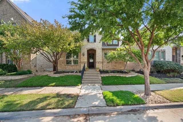 a front view of a house with yard and green space