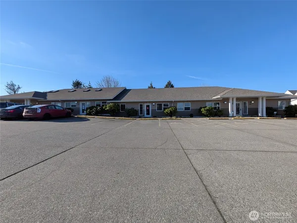 front view of house with a yard and a car parked