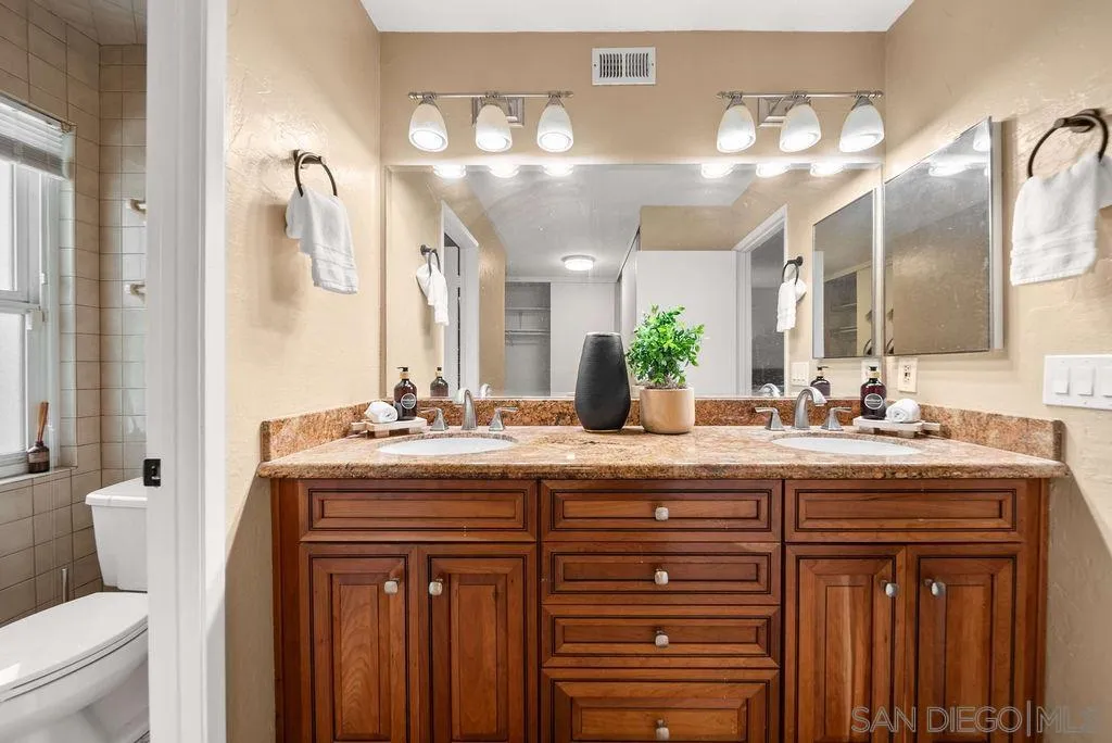 2210 Valley Road Oceanside, CA 92056 - Photo 17 of 45 a bathroom with a granite countertop sink a toilet and a large mirror