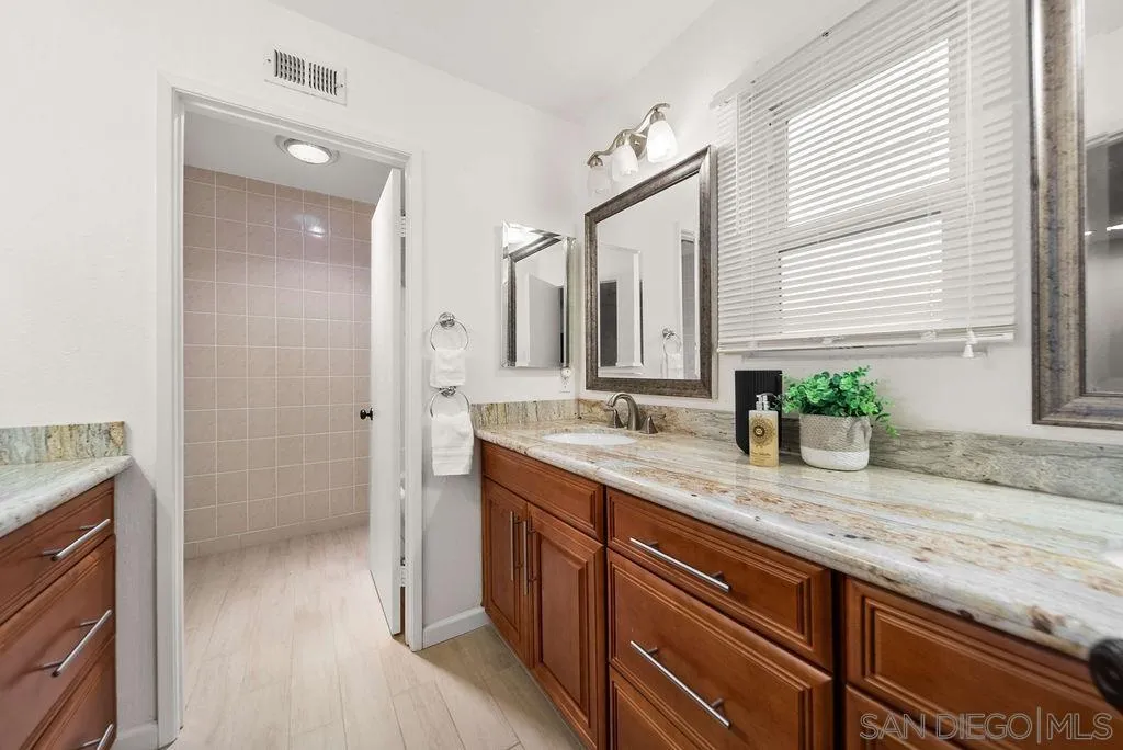 2210 Valley Road Oceanside, CA 92056 - Photo 22 of 45 a bathroom with a granite countertop sink mirror and a shower