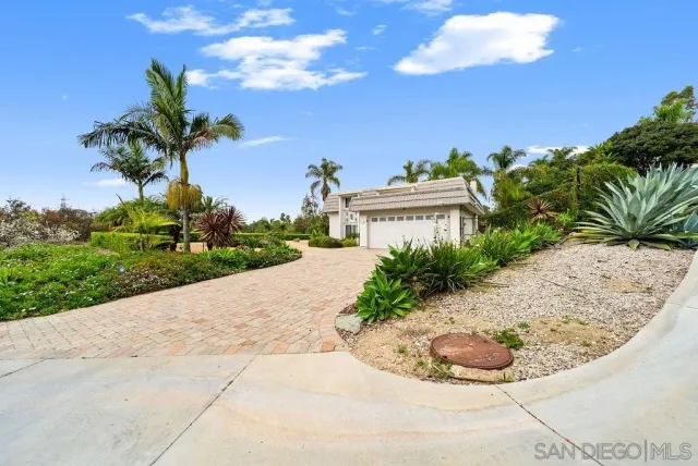 an aerial view of a house with a garden and trees