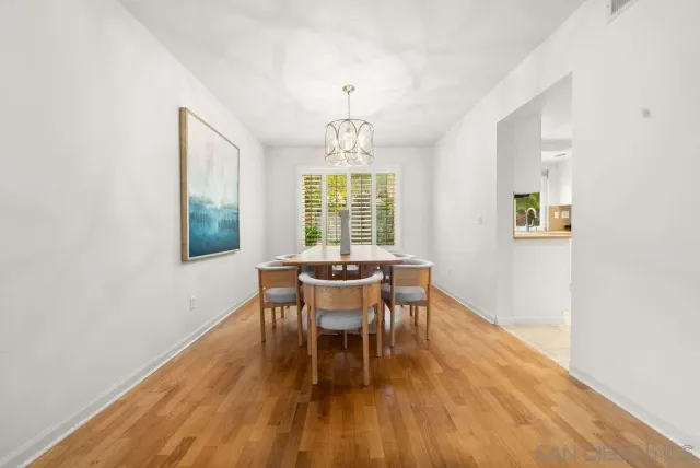 a dining room with furniture a chandelier and wooden floor