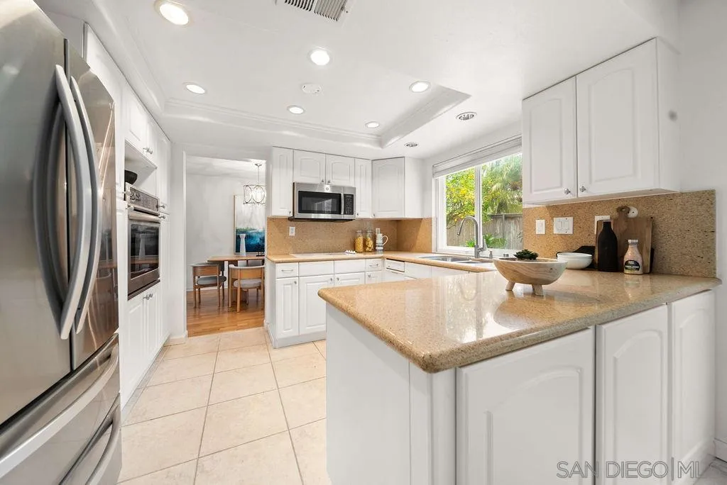 2210 Valley Road Oceanside, CA 92056 - Photo 7 of 45 a kitchen with stainless steel appliances granite countertop a sink a stove a refrigerator cabinets and chairs