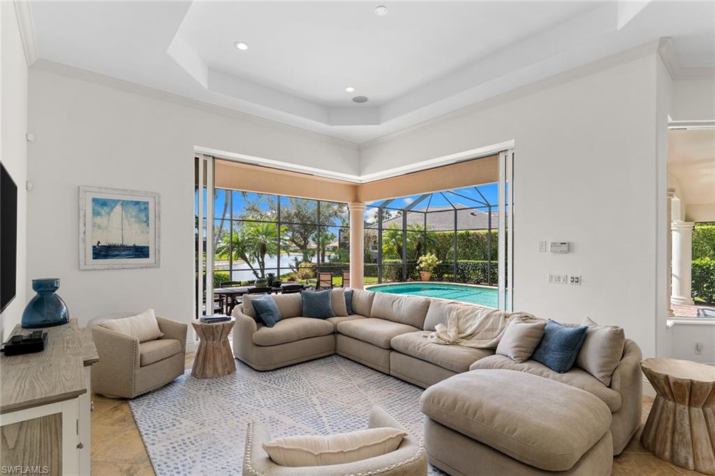 7506 Hogan Court Naples, FL 34113 - Photo 11 of 49 Living room featuring a sunroom, ornamental molding, a raised ceiling, and recessed lighting