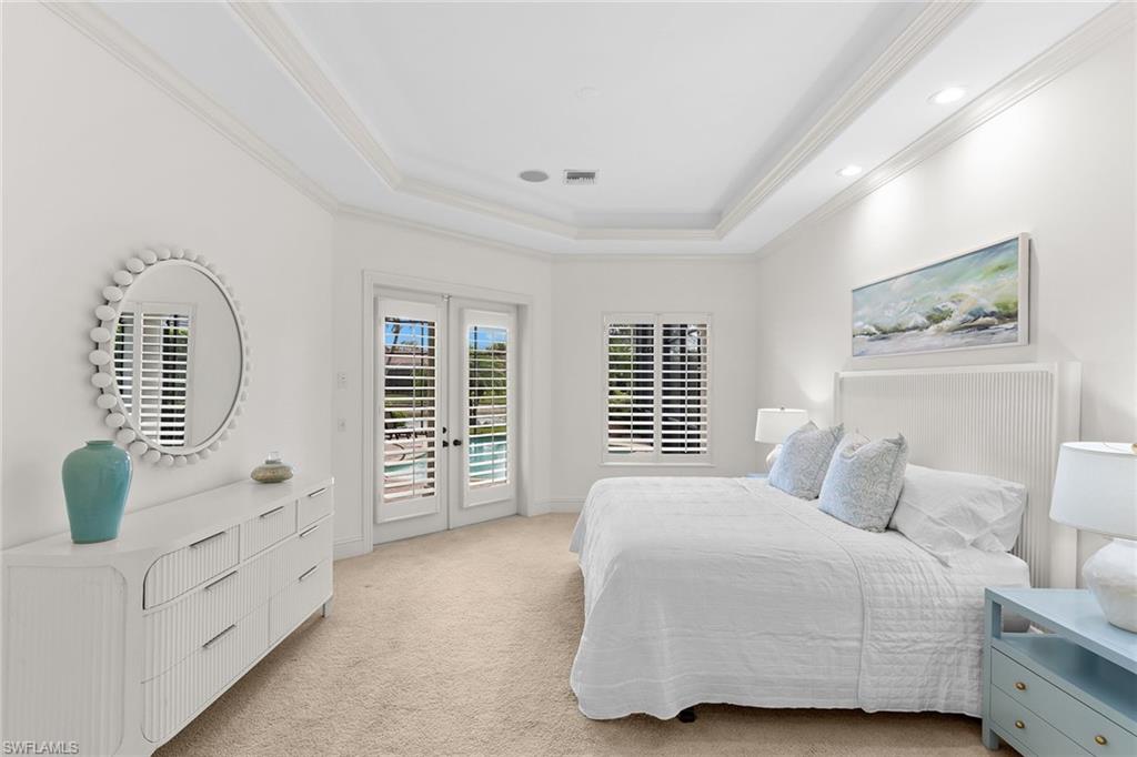 7506 Hogan Court Naples, FL 34113 - Photo 18 of 49 Bedroom with french doors, access to outside, light colored carpet, a tray ceiling, and crown molding