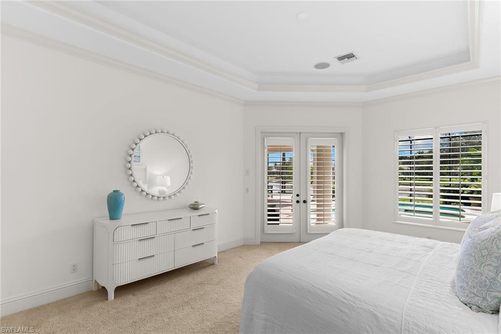 7506 Hogan Court Naples, FL 34113 - Photo 19 of 49 Bedroom featuring french doors, access to outside, light carpet, crown molding, and a raised ceiling