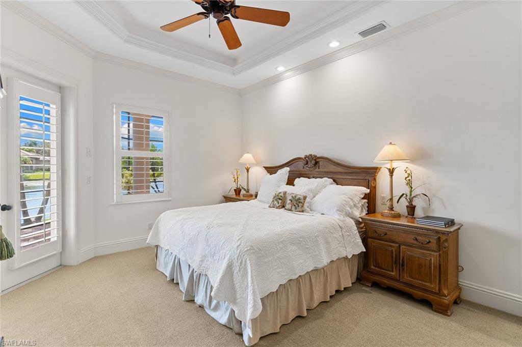 7506 Hogan Court Naples, FL 34113 - Photo 23 of 49 Bedroom featuring access to outside, a tray ceiling, ornamental molding, light colored carpet, and ceiling fan