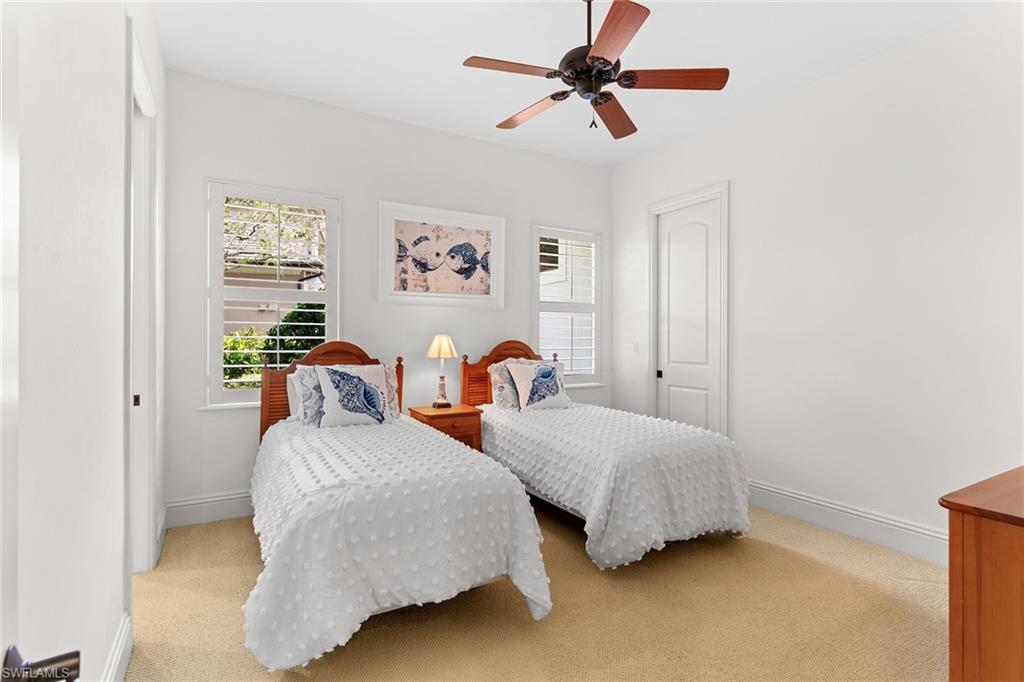 7506 Hogan Court Naples, FL 34113 - Photo 30 of 49 Carpeted bedroom with ceiling fan and a closet
