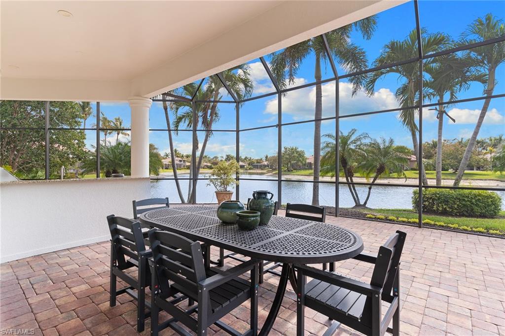 7506 Hogan Court Naples, FL 34113 - Photo 5 of 49 View of patio / terrace with glass enclosure, a sunroom, a water view, and outdoor dining area