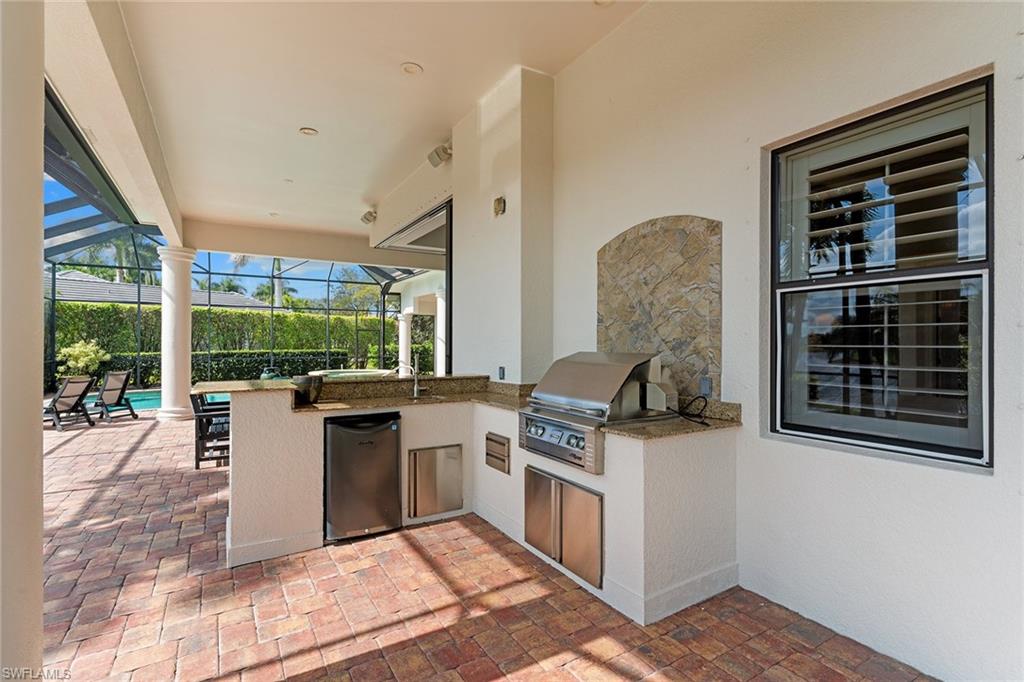 7506 Hogan Court Naples, FL 34113 - Photo 6 of 49 View of patio featuring exterior kitchen, a sunroom, and a lanai