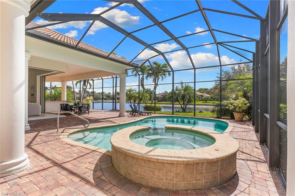 7506 Hogan Court Naples, FL 34113 - Photo 7 of 49 Integrated pool / spa featuring a sunroom, a patio, glass enclosure, and a water view