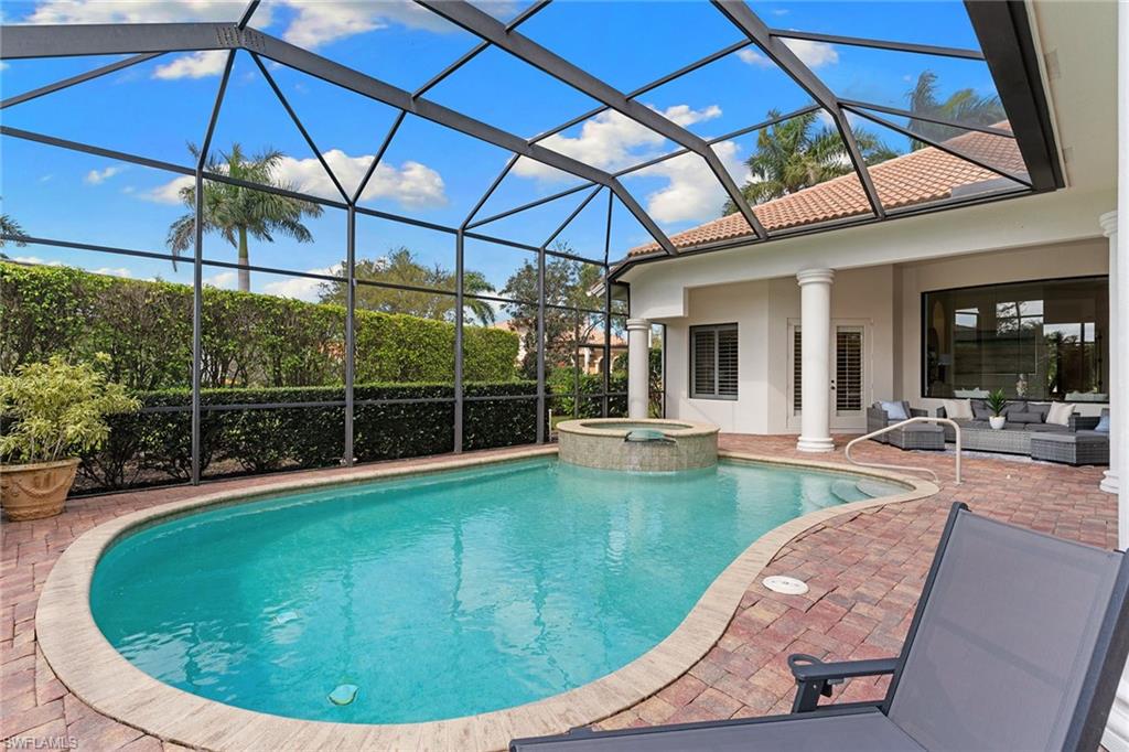 7506 Hogan Court Naples, FL 34113 - Photo 8 of 49 Integrated pool / spa featuring a sunroom, glass enclosure, an outdoor living space, and a patio