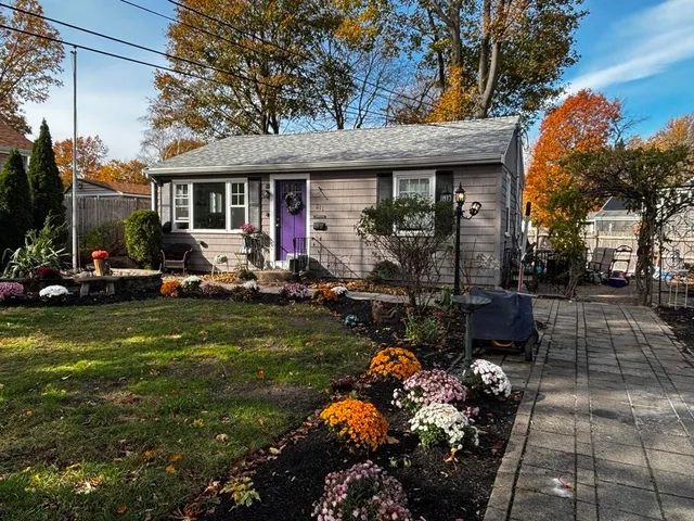 a front view of a house with a garden and sitting area