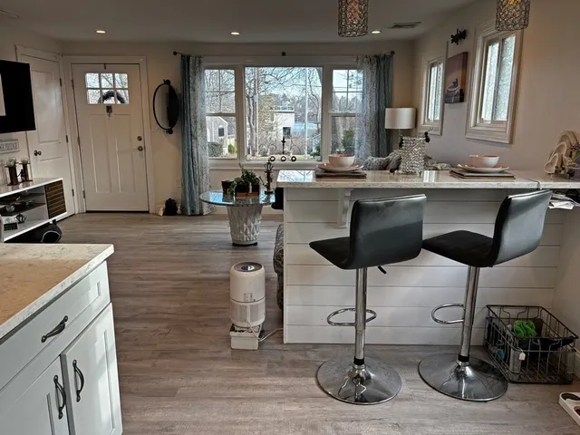 a kitchen with granite countertop a sink chairs and cabinets