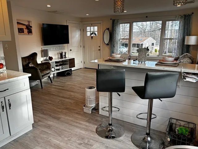 a living room with furniture a flat screen tv and a large window