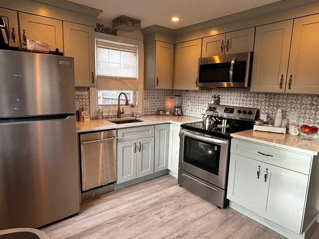 a kitchen with stainless steel appliances a refrigerator stove microwave and sink