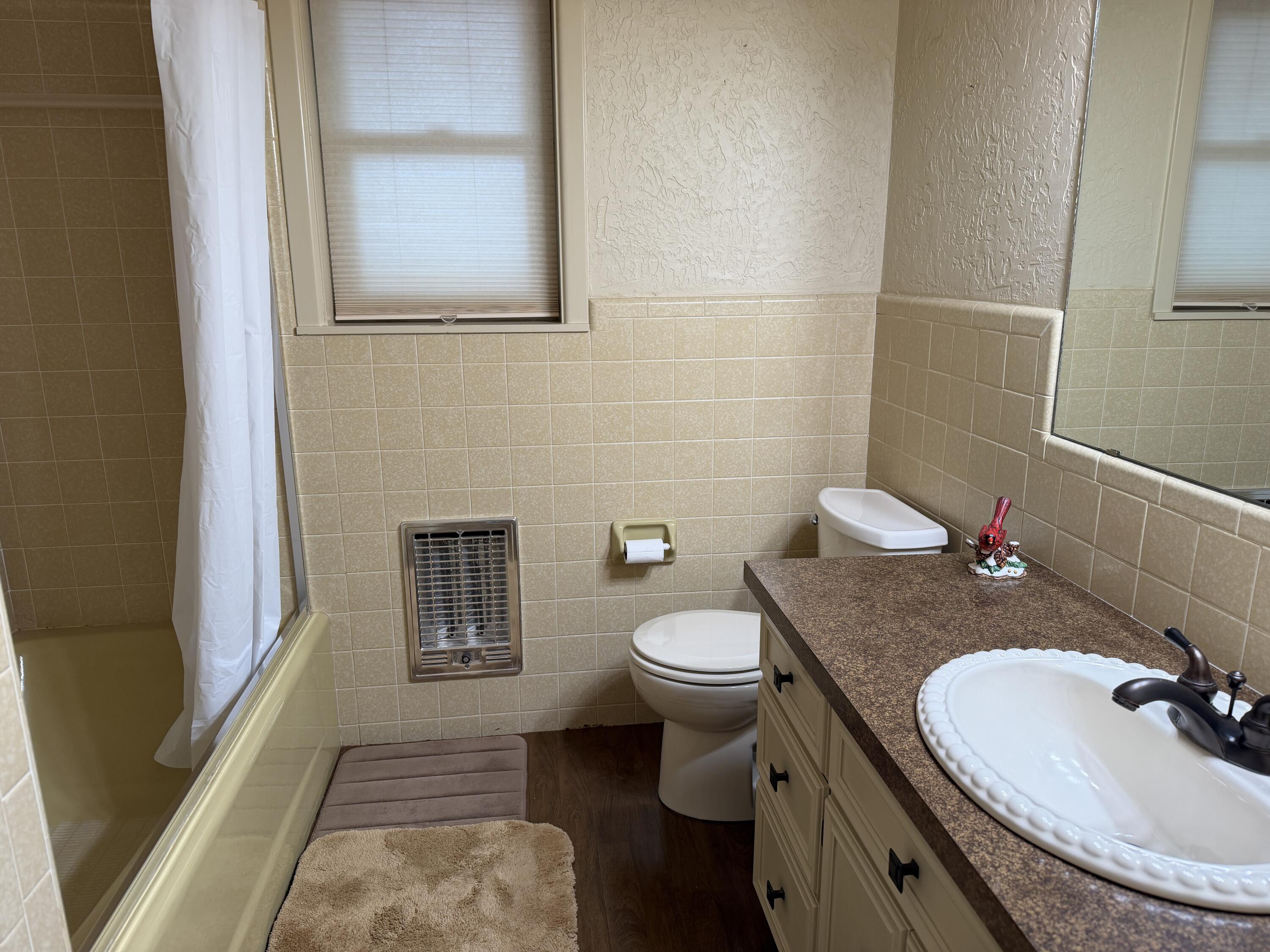 1603 South 8th Street Lamesa, TX 79331 - Photo 13 of 39 a bathroom with a granite countertop sink a toilet and a mirror