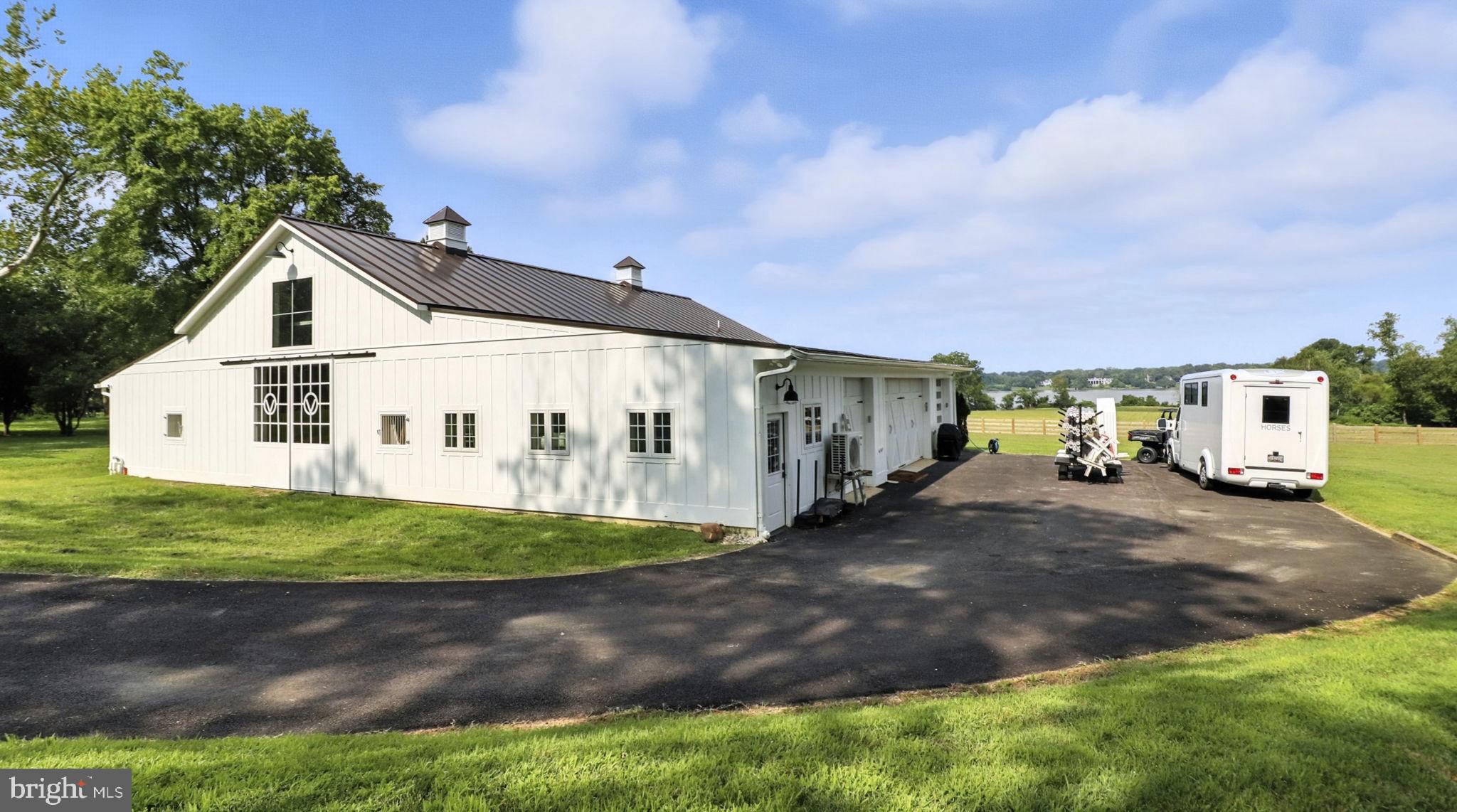 11305 Riverview Road Fort Washington, MD 20744 - Photo 25 of 59 a view of a white house next to a yard with big trees