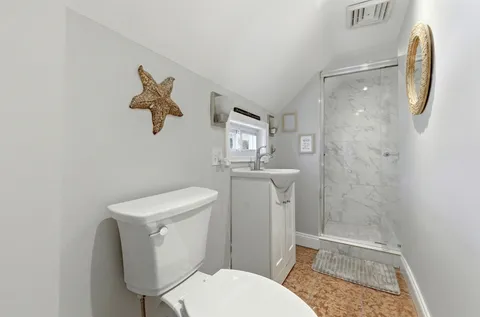 a white toilet sitting next to a bathroom sink