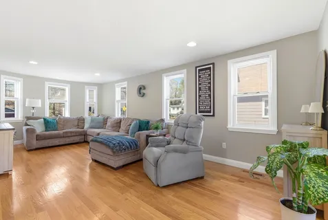 a living room with furniture and a wooden floor