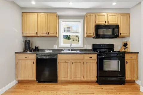 a kitchen with stainless steel appliances granite countertop a stove a sink and a microwave