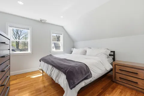 a bedroom with a bed and wooden floor
