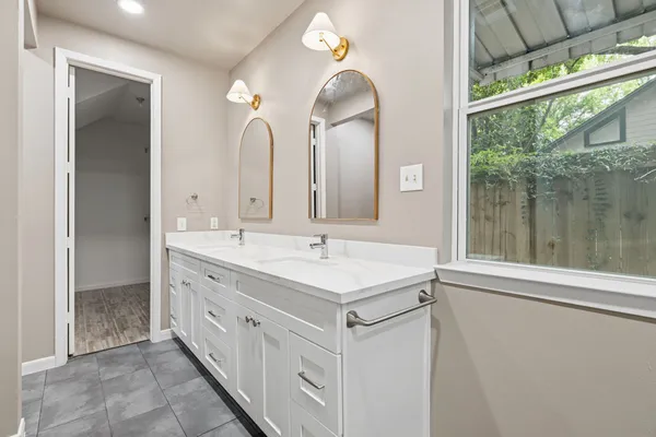 a bathroom with a double vanity sink and a mirror