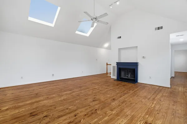 an empty room with fan and fireplace