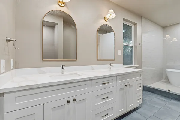 a bathroom with double vanity sinks and a mirror