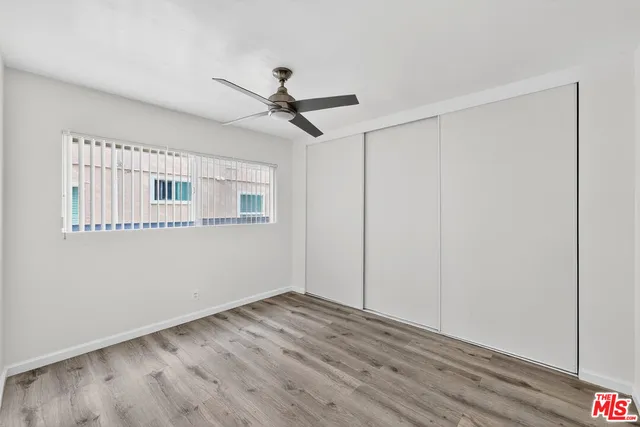 a view of a big room with wooden floor closet and windows
