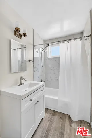 a bathroom with a sink a mirror a bathtub and shower