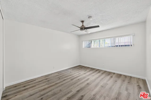 a view of a big room with wooden floor and windows