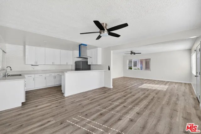 a view of a kitchen with wooden floor and a ceiling fan
