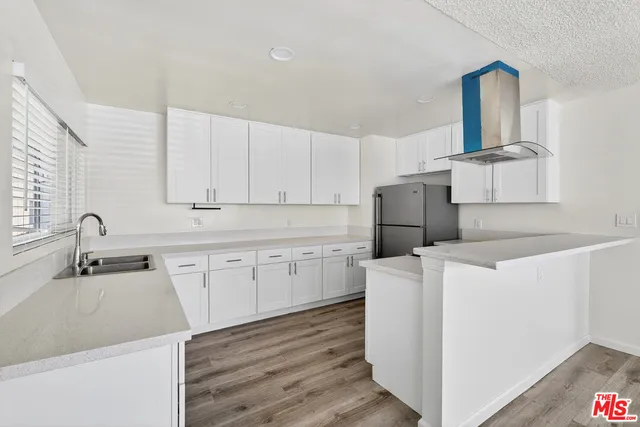 a kitchen with a sink cabinets and wooden floor