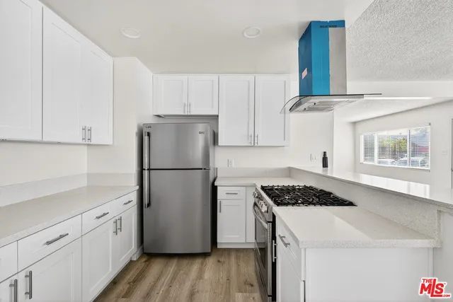 a kitchen with a refrigerator a stove a microwave and cabinets