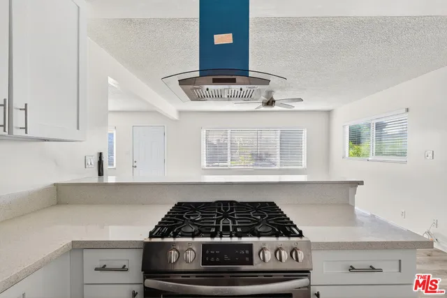 a stove top oven sitting inside of a kitchen