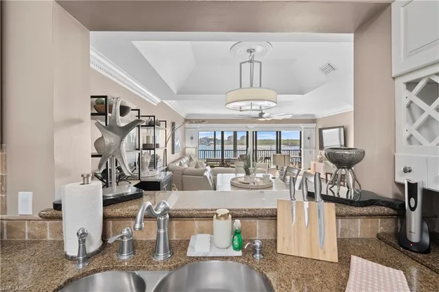 a view of a dining room with furniture a kitchen and chandelier