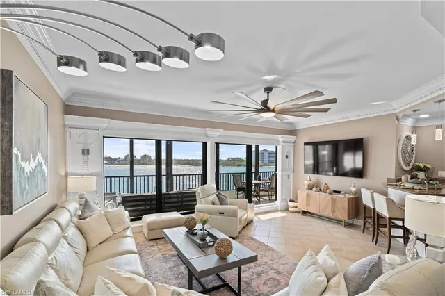 a living room with furniture flat screen tv and a large window