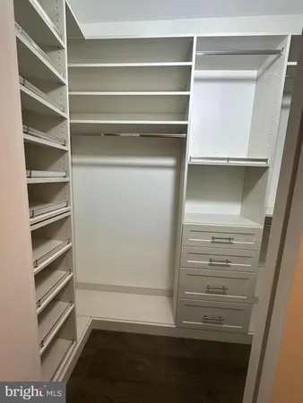 a view of walk in closet with empty racks