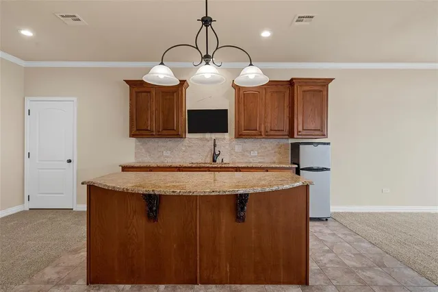 a kitchen with granite countertop a sink a counter space and cabinets