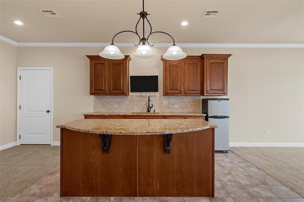 7030 Flagstone Circle Waco, TX 76657 - Photo 32 of 40 a kitchen with granite countertop a sink a counter space and cabinets