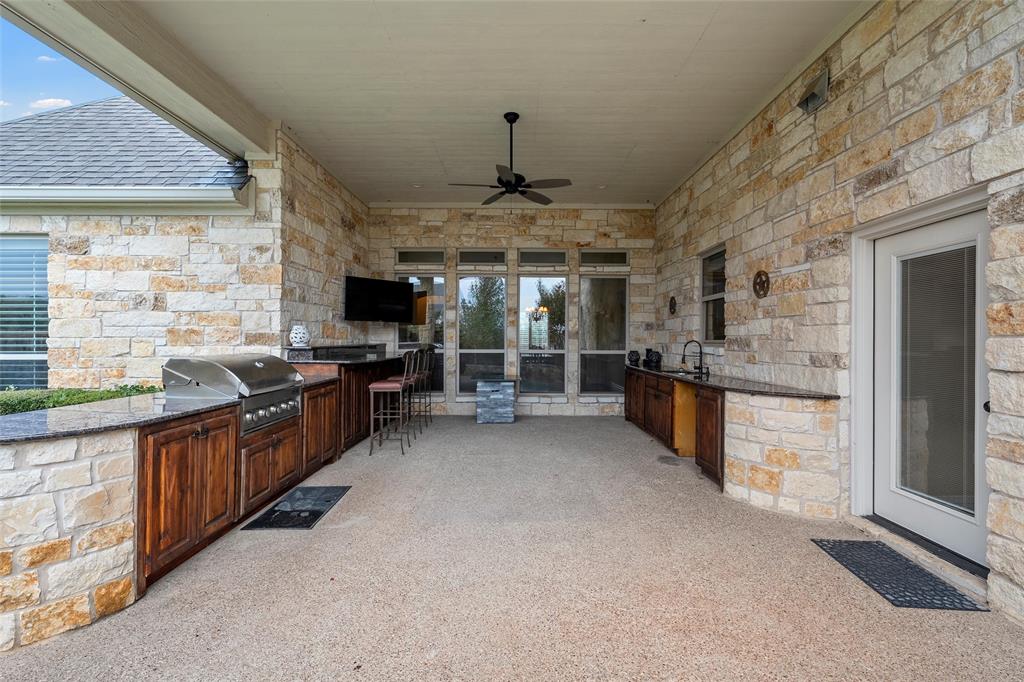 7030 Flagstone Circle Waco, TX 76657 - Photo 39 of 40 a large kitchen with stainless steel appliances granite countertop a stove top oven a sink dishwasher a dining table and chairs with wooden floor