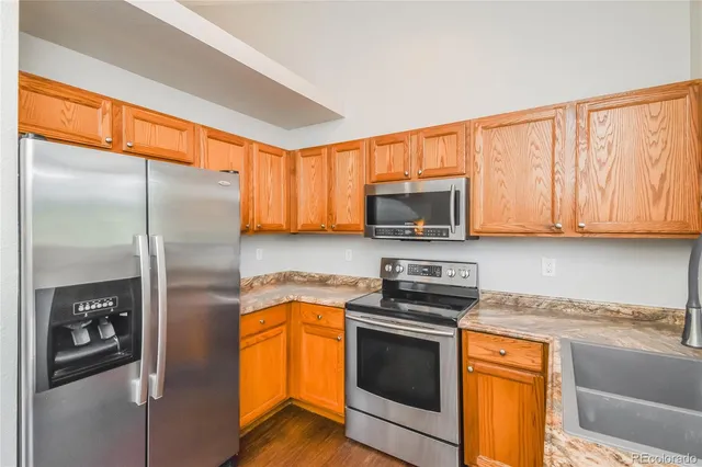 a kitchen with stainless steel appliances granite countertop a refrigerator stove and microwave