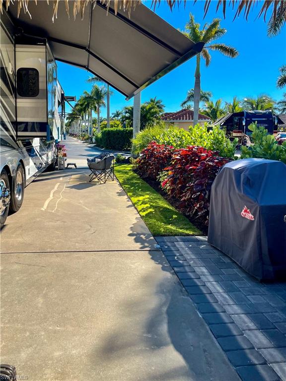 13627 Snook Circle Naples, FL 34114 - Photo 7 of 10 a view of a patio with a table and chairs under an umbrella