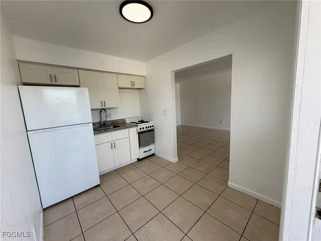 a kitchen with a refrigerator sink and cabinets